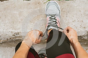 Cropped shot of female in sportswear and sneakers ready for training or running.