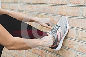 Cropped shot of female in sportswear and sneakers ready for training or running.