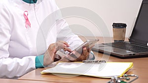 Cropped shot of a female therapist using smart phone at work