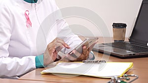 Cropped shot of a female therapist using smart phone at work