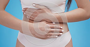 Cropped shot of female touching her belly, feeling spasm, indigestion or period cramps concept, close up