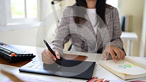 Cropped shot graphic designer working on creative desk computer while using graphic tablet at desk