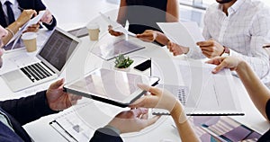 Cropped shot of a group of businesspeople sitting around the boardroom table during a meeting