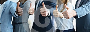 Cropped shot of a group of businesspeople standing in office showing thumb up