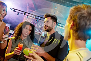 Cropped shot of group of friends, young adults, men and women having fun while toasting, drinking cocktails standing in