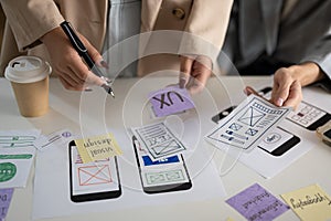 A cropped shot of a group of UX and UI graphic designers working in the meeting