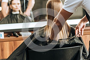 Cropped shot of hairdresser cutting hair to beautiful young woman