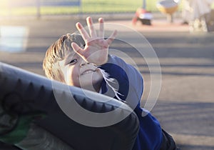 Cropped shot of happy school boy playing in the playground in evening, Child playing outdoor in the park after back from school