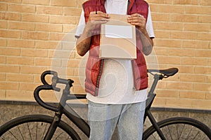 Cropped shot of a male courier holding paper bag with food from