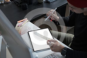 Cropped shot of male creative graphic designer is working on color swatches and drawing on graphics tablet at workplace.