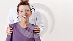 Cropped shot of male doctor helping teenaged disabled boy with cerebral palsy, posing isolated over white background