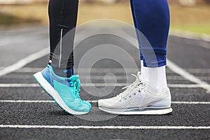 Cropped shot of a male and female legs in running shoes close to