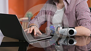 Cropped shot of man with bionic arm work on computer at home.