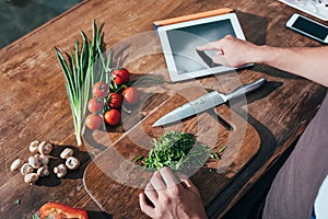 cropped shot of man cooking with tablet