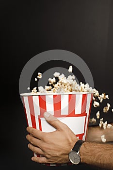 cropped shot of man holding cardboard bucket of popcorn