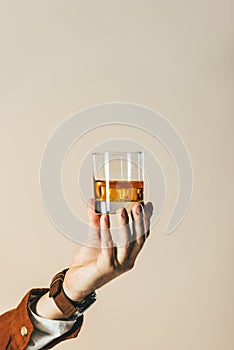 cropped shot of man holding glass of whiskey
