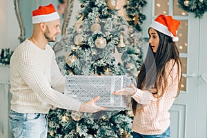 Cropped shot of a man surprising his girlfriend with a Christmas gift.