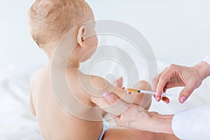 Cropped shot of medical worker making injection for cute baby boy