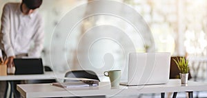 Cropped shot of modern office room with laptop computer and office supplies with office environment background