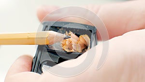 Cropped shot of pair of hands sharpen a pencil