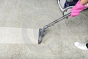 cropped shot of person cleaning white carpet with vacuum