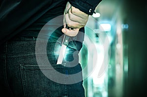 Cropped shot of a person hiding hand made knife behind his back