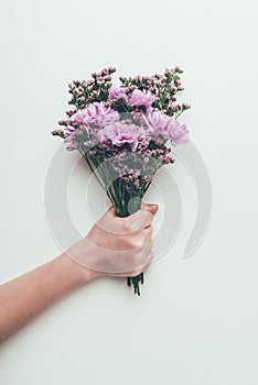 Cropped shot of person holding beautiful elegant bouquet of tender flowers