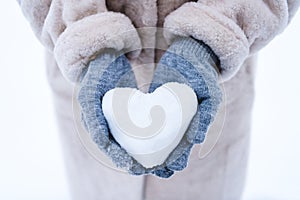 cropped shot of person holding heart symbol made from snow