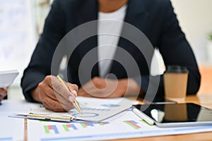 Cropped shot, Professional Asian businessman working at his desk, pointing pen on financial report