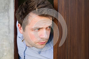 Cropped shot of senior man spying and entering through the door as concept of nosy man