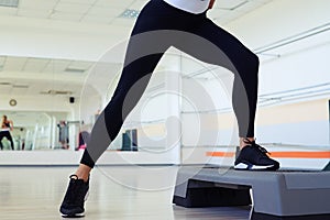 Cropped shot of skinny woman legs doing step aerobics photo