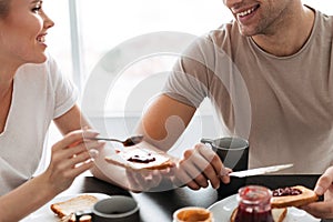 Cropped shot of smiling couple eating breakfast in the morning