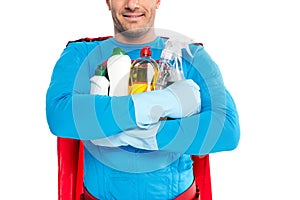 cropped shot of smiling superhero holding cleaning supplies