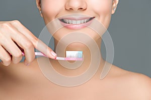 cropped shot of smiling woman holding tooth brush in hand