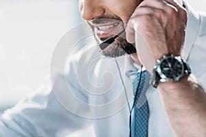 cropped shot of support hotline worker in shirt with tie talking by headphones