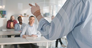 Cropped shot of teacher gesturing hands while giving lecture to students in classroom