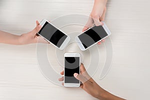 cropped shot of teenagers holding smartphones with blank screens