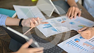 Cropped shot of two businesspeople brainstorming on their project on wooden table