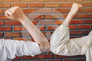 Cropped shot of two women bump elbows for greeting during coronavirus epidemic.