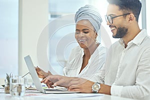 Two heads are always better than one. Cropped shot of two young diverse businesspeople working together on a laptop in