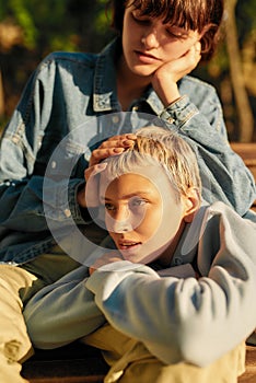 Cropped shot of two young girls relaxing on the bench in the city park on a sunny day. Lesbian couple spending time