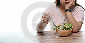 Cropped shot of an unhappy overweight woman bored of diets eating healthy food.