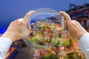 Cropped shot view of man`s hands making photo on mobile phone camera is Jiufen Old Street in New Taipei City, Taiwan