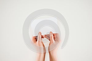 cropped shot of woman holding blank paper in hands