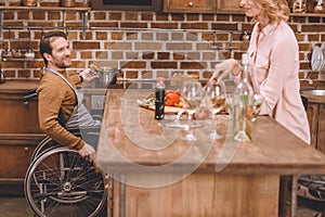 cropped shot of woman with man in wheelchair cooking dinner together