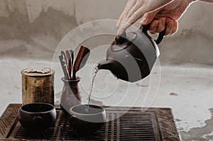 Cropped shot of woman pouring tea in traditional chinese teaware