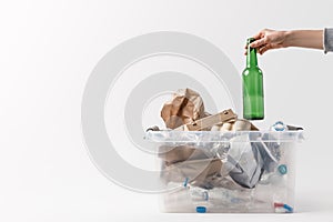 cropped shot of woman putting glass bottle into container with plastic bottles, recycle concept