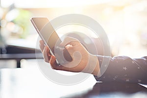 Cropped shot of woman`s hands holding cell phone making shopping online. Visual effects. Woman using mobile phone while sitting at