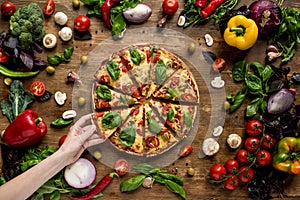 Woman taking slice of pizza