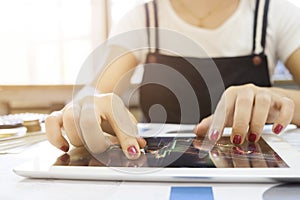 Cropped shot of Woman Touching stock market graph on a touch screen device in home. Trading on stock market concept.